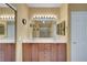 Bathroom with double sinks, wood cabinets, tile floors, and large mirror at 4802 Regalo Bello St, Las Vegas, NV 89135
