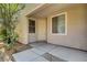 Covered front porch boasts a white entry door, beige walls, and a small garden at 4802 Regalo Bello St, Las Vegas, NV 89135