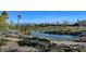 Picturesque golf course view with a pond, palm trees, and lush green landscaping at 4802 Regalo Bello St, Las Vegas, NV 89135