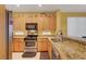 The kitchen is equipped with updated stainless steel appliances, granite counters, and warm wood cabinets at 4802 Regalo Bello St, Las Vegas, NV 89135