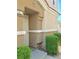 The entryway showcases a beige exterior with trimmed bushes and a well-lit porch at 4830 Double Down Dr # 102, Las Vegas, NV 89122
