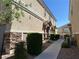 A townhouse exterior with maintained bushes along a private walkway at 4830 Double Down Dr # 102, Las Vegas, NV 89122