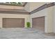 Two car garage with brown doors and tan stucco exterior and tile roof for two homes in Las Vegas, Nevada at 5250 S Rainbow Blvd # 2183, Las Vegas, NV 89118
