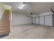 Spacious garage with stairs to the living area and a large garage door at 5250 S Rainbow Blvd # 2183, Las Vegas, NV 89118