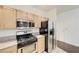Well-lit kitchen featuring stainless steel appliances and light wood cabinets at 5250 S Rainbow Blvd # 2183, Las Vegas, NV 89118