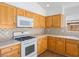 Bright kitchen features light wood cabinets, white countertops and appliances, and tile backsplash at 5373 Blue Oat Ave, Las Vegas, NV 89141