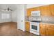 Well-lit kitchen featuring wooden cabinets, laminate countertops, and white appliances at 5373 Blue Oat Ave, Las Vegas, NV 89141