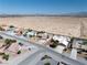 Stunning aerial view of a desert home with a sparkling pool and a solar panel array on the roof at 5450 Grain Mill Rd, Pahrump, NV 89061