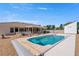 Resort-style backyard with a sparkling pool, covered patio, lush landscaping, and outdoor dining area at 5450 Grain Mill Rd, Pahrump, NV 89061