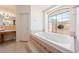 Bright bathroom features a large tub with jets and a large window that lets in natural light at 5450 Grain Mill Rd, Pahrump, NV 89061