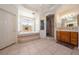An open bathroom features a large tub, a shower, and a vanity with plenty of counter space at 5450 Grain Mill Rd, Pahrump, NV 89061