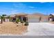 Charming single-story home showcasing a well-manicured yard, three-car garage, and inviting desert landscaping at 5450 Grain Mill Rd, Pahrump, NV 89061
