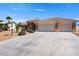 Charming single-story home showcasing a well-manicured yard, three-car garage, and inviting desert landscaping at 5450 Grain Mill Rd, Pahrump, NV 89061