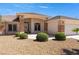 Inviting home entrance with desert landscaping, decorative stone accents, and an arched doorway at 5450 Grain Mill Rd, Pahrump, NV 89061