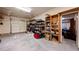 Garage space with storage shelves, garage door, and access to additional storage space at 5450 Grain Mill Rd, Pahrump, NV 89061