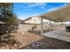 Wide shot of a backyard with a covered patio, hardscape and rock landscaping at 5544 Cloudy Glen St, North Las Vegas, NV 89031