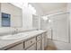Bright bathroom featuring double sinks, white cabinetry, and shower with sliding glass doors at 5544 Cloudy Glen St, North Las Vegas, NV 89031