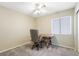 Neutral-toned bedroom with a ceiling fan, window, wooden desk and rolling office chair, and light-colored walls at 5544 Cloudy Glen St, North Las Vegas, NV 89031