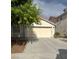 Exterior view of the home featuring a two-car garage and driveway at 5544 Cloudy Glen St, North Las Vegas, NV 89031