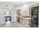 Well-lit kitchen featuring stainless steel appliances, gray cabinets, and tile backsplash at 5544 Cloudy Glen St, North Las Vegas, NV 89031