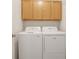 Laundry room with a side-by-side washer and dryer set under wooden cabinets at 5544 Cloudy Glen St, North Las Vegas, NV 89031