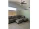 Cozy living room featuring a ceiling fan and L-shaped sofa with ottoman at 5544 Cloudy Glen St, North Las Vegas, NV 89031