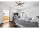 Bedroom with a ceiling fan, wooden floors, an en suite bath, and natural lighting at 5544 Cloudy Glen St, North Las Vegas, NV 89031