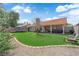 Expansive backyard with artificial turf, a covered patio, lush landscaping, and privacy fencing at 5884 Deer Valley Dr, Las Vegas, NV 89156