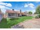 Large backyard with artificial turf, mature trees, a trampoline, and a tiled roof home in the background at 5884 Deer Valley Dr, Las Vegas, NV 89156