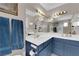 Bright bathroom featuring double sinks, white countertops, blue cabinets, and large mirrors with vanity lighting at 5884 Deer Valley Dr, Las Vegas, NV 89156