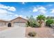 Charming single-story home featuring a well-maintained front yard with a palm tree and a two-car garage at 5884 Deer Valley Dr, Las Vegas, NV 89156