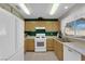 Bright kitchen features wood cabinets, white appliances, and a window offering ample natural light at 5884 Deer Valley Dr, Las Vegas, NV 89156