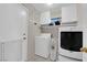 Efficient laundry room equipped with a washer, dryer, shelving, and storage cabinets at 5884 Deer Valley Dr, Las Vegas, NV 89156