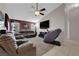 Cozy living room featuring carpet, fan, tv, and comfortable leather seating, perfect for relaxation and entertainment at 5884 Deer Valley Dr, Las Vegas, NV 89156
