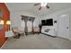 Bright bedroom features plush carpeting, a ceiling fan, and an entertainment center with a TV at 605 Devonhall St # 202, Las Vegas, NV 89145
