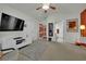 Carpeted bedroom featuring a ceiling fan, modern entertainment center, and access to the bathroom at 605 Devonhall St # 202, Las Vegas, NV 89145
