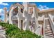 Condo exterior features well-maintained landscaping, stairways to upper units, and a neutral color scheme at 605 Devonhall St # 202, Las Vegas, NV 89145