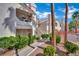 Apartment complex view with lush greenery and a pool, showcasing the building's architectural details at 605 Devonhall St # 202, Las Vegas, NV 89145