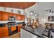 Bright kitchen featuring black appliances, creative orange cabinetry, and a large island with bar seating at 605 Devonhall St # 202, Las Vegas, NV 89145
