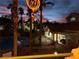 Scenic dusk view of community pool and cabana surrounded by palm trees and buildings with a fiery sunset at 605 Devonhall St # 202, Las Vegas, NV 89145