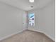 Cozy bedroom with carpet, a window view, and a door for easy access at 6282 Dollar Bill Ct, Las Vegas, NV 89141
