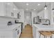 Bright kitchen with modern white cabinets, stainless appliances, and breakfast bar seating at 6282 Dollar Bill Ct, Las Vegas, NV 89141
