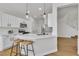 Well-lit kitchen featuring white cabinets, modern appliances, and a breakfast bar at 6282 Dollar Bill Ct, Las Vegas, NV 89141