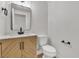 Modern powder room features a wood vanity, marble countertop, and black fixtures at 6282 Dollar Bill Ct, Las Vegas, NV 89141