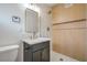 Bathroom featuring a sleek vanity, a frameless mirror, and a shower with wood-look tile surround at 6320 Dayton Ave, Las Vegas, NV 89107