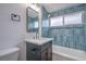 Stylish bathroom with a blue tiled shower-tub combo, modern vanity, and contemporary fixtures at 6320 Dayton Ave, Las Vegas, NV 89107