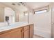 This primary bathroom features a tub, shower, and wood vanity with dual sinks at 6620 Tulip Falls Dr, Henderson, NV 89011
