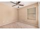 This bedroom features neutral carpet, a ceiling fan and ample natural light at 6620 Tulip Falls Dr, Henderson, NV 89011