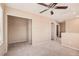 This carpeted bedroom features a ceiling fan, walk-in closet, and neutral paint at 6620 Tulip Falls Dr, Henderson, NV 89011