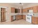 The spacious kitchen features wood cabinets, laminate countertops and a white range at 6620 Tulip Falls Dr, Henderson, NV 89011